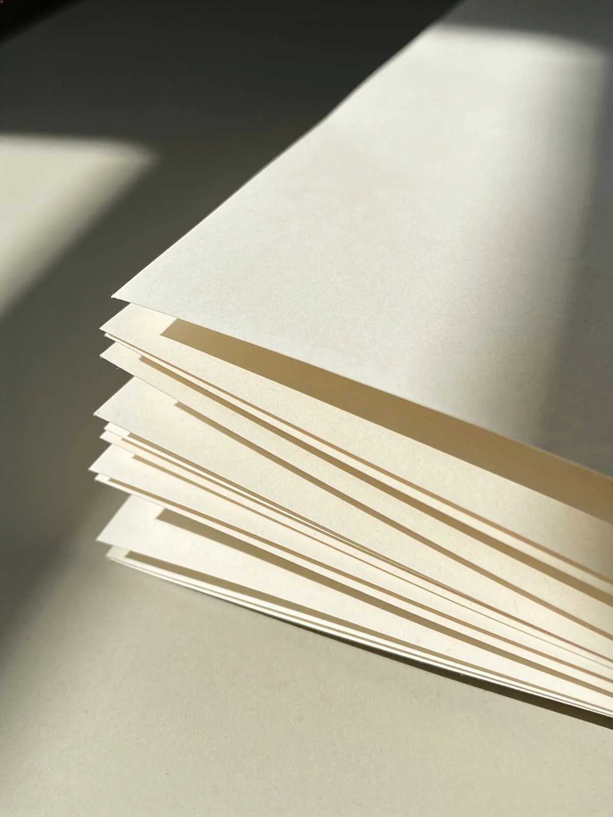 Ein Stapel loser Papierbögen im Streiflicht