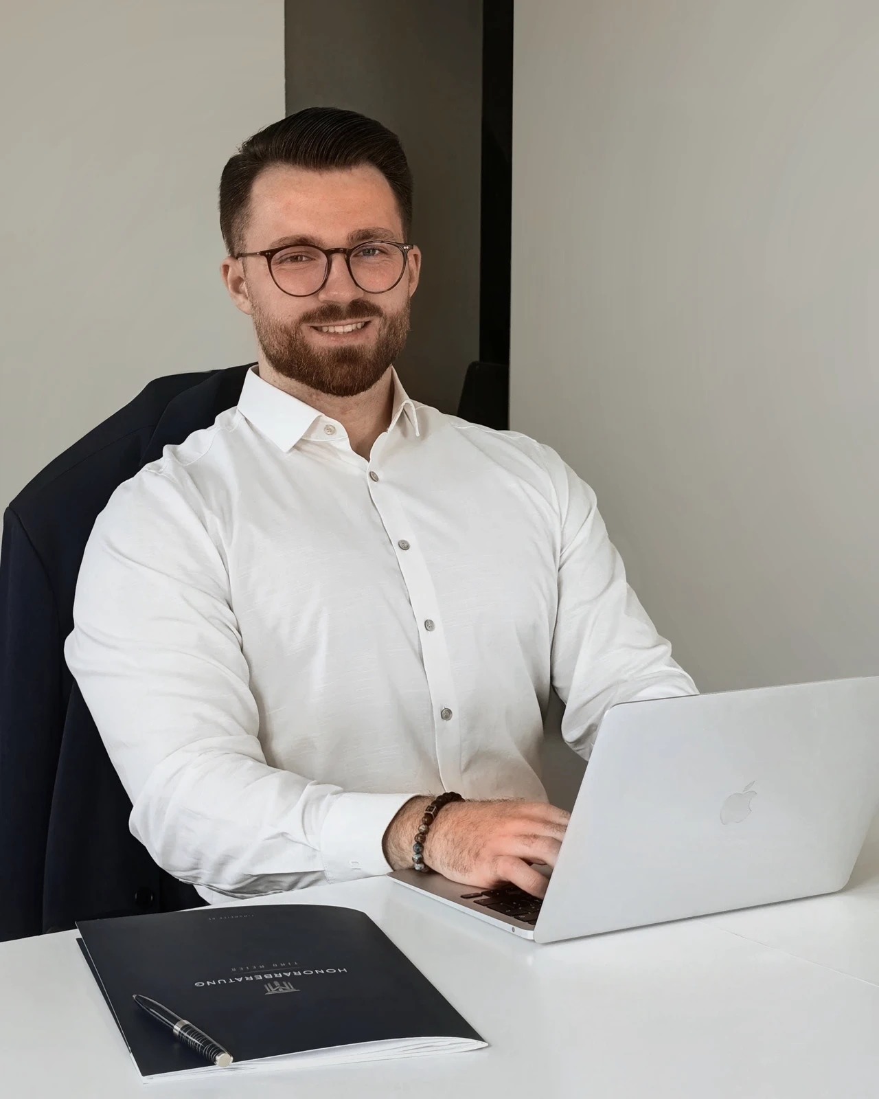 Timo Meier am Schreibtisch mit Laptop und Beratungsunterlagen